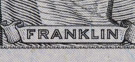 Along the bottom of the $100 bill under the Franklin  portrait the repesting text 'USAUSA'.