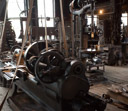 Now some of those machines driven by that common shaft. In the background is a drill press, in the foreground is a lathe. Note that some of the machines have been modified to run off of electric motors.