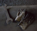 Wrench and the well worn gloves of working hands await the workman's return.