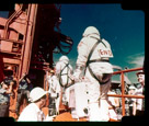 Astronauts Lovell and Aldrin entering the Gemini XII space craft. Gemini XII was the final Gemini flight. Rendezvoused and docked manually with its target Agena and kept station with it during EVA. Aldrin set an EVA record of 5 hours 30 minutes for one space walk and two stand-up exercises, and demonstrated solutions to previous EVA problems.