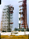 Saturn V on the mobile launcher with the mobile service structure to the left. The mobile service structure is mounted on the crawler and is being moved up to surround the Saturn V rocket. The tower on the mobile launcher is 400 feet tall, the Saturn V with launch escape tower is about 365 feet tall and the mobile service structure is 300+ feet tall. All were moved around using the mobile trasnsporter which is under the mobile service structure in this picture.   The Saturn V in this picture may be a mock-up used to make sure all the major pieces played well together.