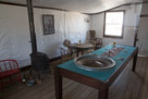 A reconstructed gambling area.  Note the stove up on bricks. They have set this up to look likie the prople have just stepped out. Some of the furniture is from the original city. Some is period. Some are reconstruction.