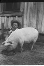 Age 7 years, 6 months, 1 day.
Me and the pig Frank. I am the one in the hat. We had had Frank 4 months.  Here Frank is eating off the lid of a 5 gallon can.