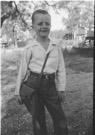 Aged 7 years 5 months
October 19, 1949. 
I appear to be on the way to school. There appears to be the back of a truck in the upper right. The background looks like the trap behind the house at the Johnson place.