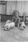 Aged 7 years, 2 months, 5 days.
July 24, 1949.
Pig is Frank. I am the one in the hat. Frank was the runt of a litter or Frank Walston's pigs who lived at the next farm to the West.  Frank knew what to do with a hub cap full of milk. Appears to have a foot in the hub cap also. Frank did not have good table manners.