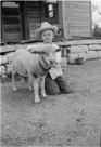 Aged 9 years, 2 months, 1 day.
July 20, 1951.
Lamb is Roy, named for Roy Spinks who gave it to me. Roy is also the one that gave me the nickname 'Uncle Wiggily'. Dog in the background is Suppie.  Still have the iron in front of the porch. This is at the Ellis Place. The porch is now gone from the front of the house which is used as a barn.