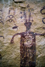And a closer look at this figure. The nine 'birds' circling his head are more obvious here. Some of the 'birds' are shown with both wings above the body, some with a wing on either side. The 'bird' to the left of the head is definitely a separate element from the nine above.