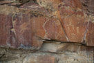 Here we have a number of glyphs that obviously span a wide time range. The sheep in the left center is quite old, is in bold outline and the feet may be cloven. To the left of the sheep is an indistinct figure and then what appears to be something riding a broom. The glyphs could probably be recovered by an artist making annotations of a enlarged photograph at the site.  The figures at the right are more recent and somewhat whimsical. Some have elaborate head treatment. Then there is the thing with the long legs? and a handle? in the center.