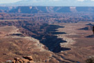 Buck Canyon. The White Rim trail is named for the Premian age White Rim Sandstone that defines the rim of Buck Canyon here.  This very hard sandstone layer forms the top of a terrace for much of Canyonlands National Park.  This is the top of the Permian age geology. Above this is Triasic age formations. Geology of the White Rim sandstone is 245 million years old. Below the White Rim Sandstone is Organ Rock Shale.