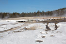 Beehive geyser inactive state. Steam puffs out from time to time. In spite of its large eruptions  the snow remains close to the cone. The prevaling wind carries most of the erruption the other way. Note the icicles off the boardwalk.